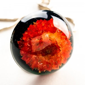 Biżuteria artystyczna z czerwonym kwiatem.