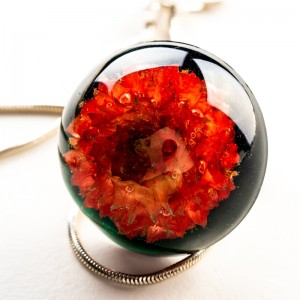 Biżuteria artystyczna z czerwonym kwiatem.