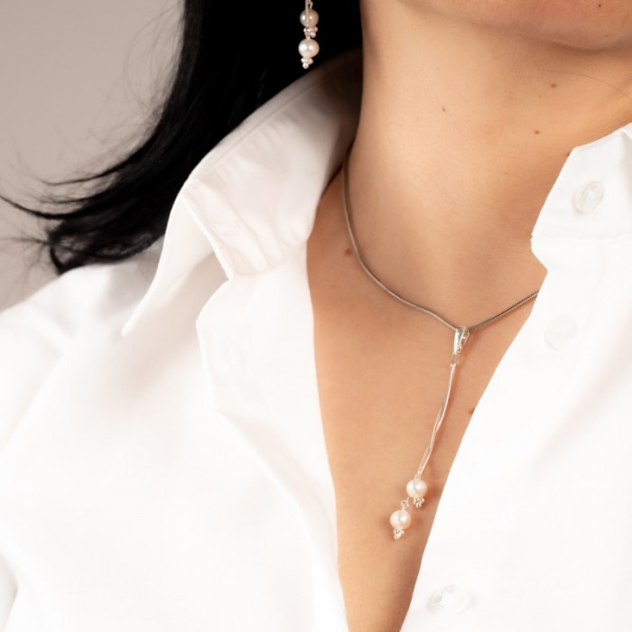 Naszyjnik z perłami do białej koszuli.