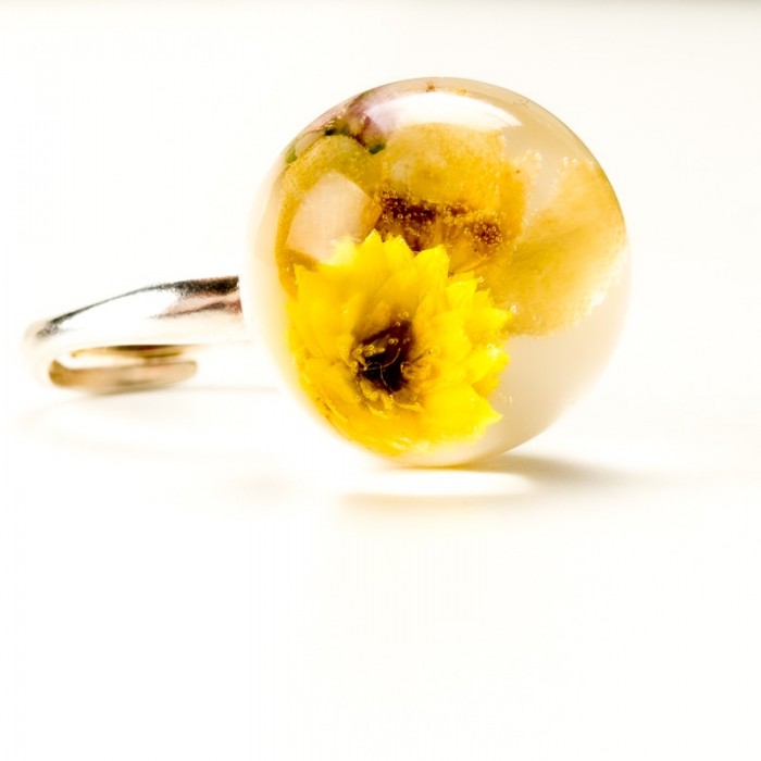 Pierścionek z suszonymi żółtymi kwiatami.