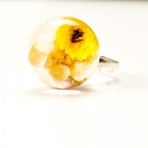 Pierścionek z suszonymi żółtymi kwiatami.