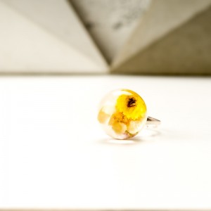 Pierścionek z suszonymi żółtymi kwiatami.