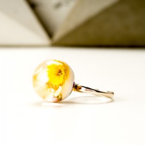 Pierścionek z suszonymi żółtymi kwiatami.