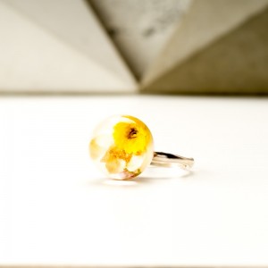 Pierścionek z suszonymi żółtymi kwiatami.