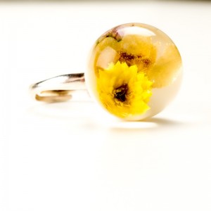 Pierścionek z suszonymi żółtymi kwiatami.