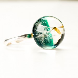 Pierścionek z zielonym oczkiem i dmuchawcem.