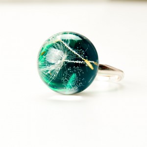 Pierścionek z zielonym oczkiem i dmuchawcem.