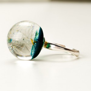 Pierścionek z zielonym oczkiem i dmuchawcem.