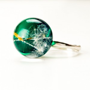 Pierścionek z zielonym oczkiem i dmuchawcem.