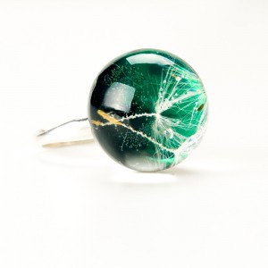 Pierścionek z zielonym oczkiem i dmuchawcem.