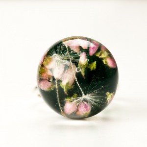 Pierścionek z motywem kwiatowym i zielonym tłem.