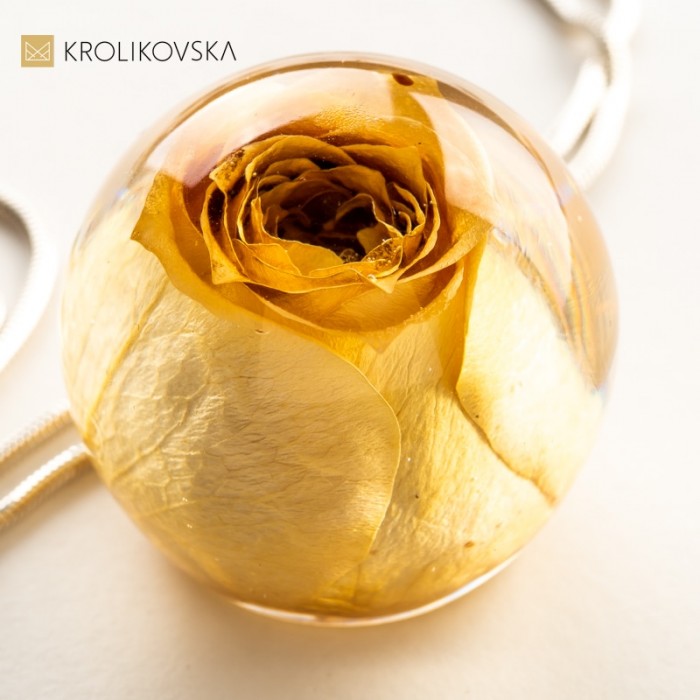 Naszyjnik z różą oprawioną w srebro.