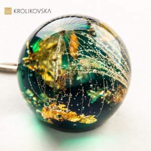 Zielony naszyjnik z dużym dmuchawcem.