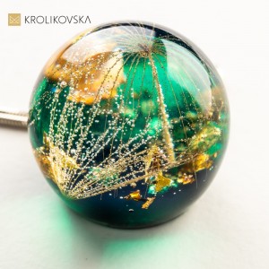 Zielony naszyjnik z dużym dmuchawcem.