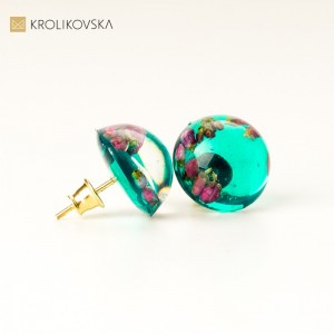 Wkrętki do uszu z zielonym oczkiem.