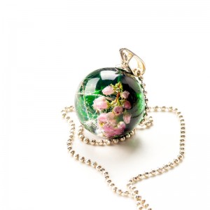 Naszyjnik artystyczny zielony z różowymi kwiatami.