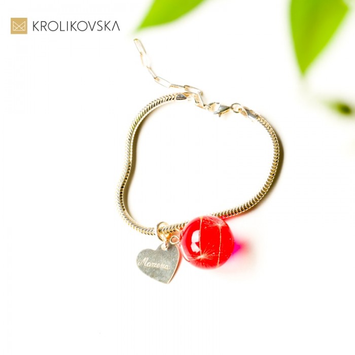 Srebrna bransoletka z czerwoną zawieszką.