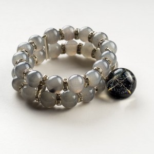 Bransoletka ręcznie robiona z szarych koralików z dmuchawcem w czarnej zawieszce