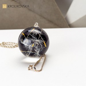 Nasiona mniszka lekarskiego w czarnym naszyjniku.