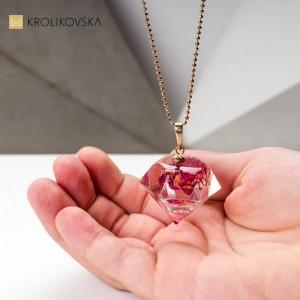 Autorski naszyjnik z różowym kwiatem.