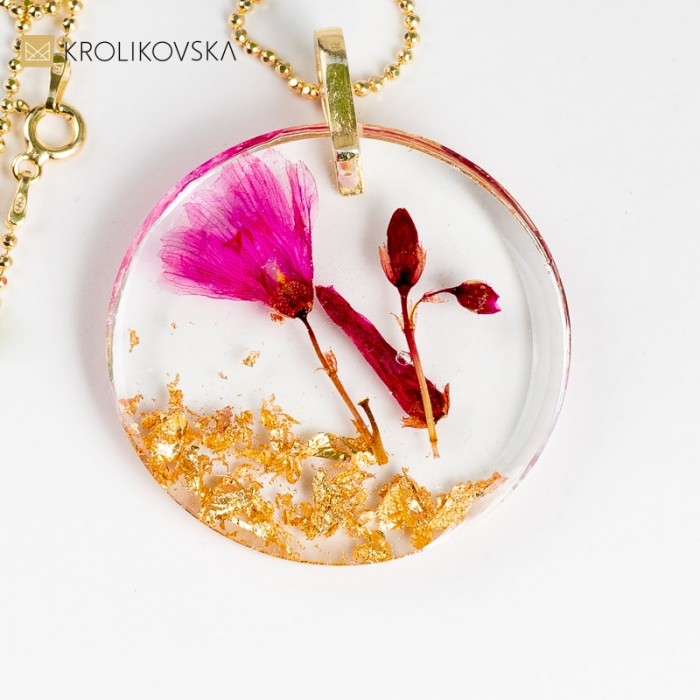 Zawieszka do naszyjnika z różowym kwiatem.