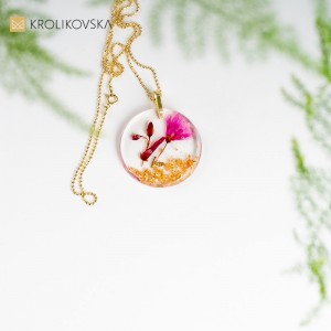 Zawieszka do naszyjnika z różowym kwiatem.