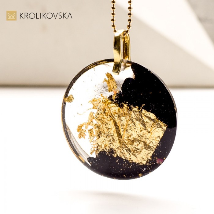 Wisiorek czarny z płatkami złota.