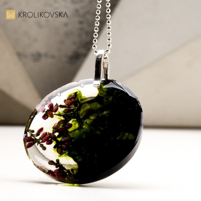 Naszyjnik ciemno zielony z kwiatami zatopionymi w żywicy.
