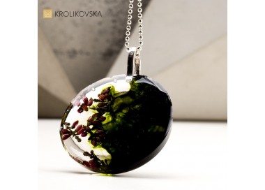 Naszyjnik ciemno zielony z kwiatami zatopionymi w żywicy.