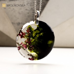Naszyjnik ciemno zielony z kwiatami zatopionymi w żywicy.