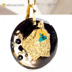 Artystyczny naszyjnik z żywicy, na której złote detale tworzą rysunek.1