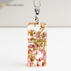 Naszyjnik z kwiatem w żywicy, artystyczna biżuteria inspirowana naturą.