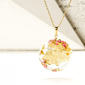 Złote płatki, wrzos, dmuchawiec  na pozłacanym łańcuszku.