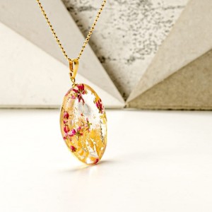 Złoty naszyjnik damski z żywicy na pozłacanym łańcuszku z prawdziwymi różowymi wrzosami z okrągłą zawieszką i złotymi płatkami