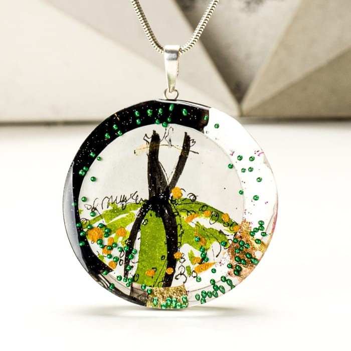 Zielona sukienka w grafice biżuterii.